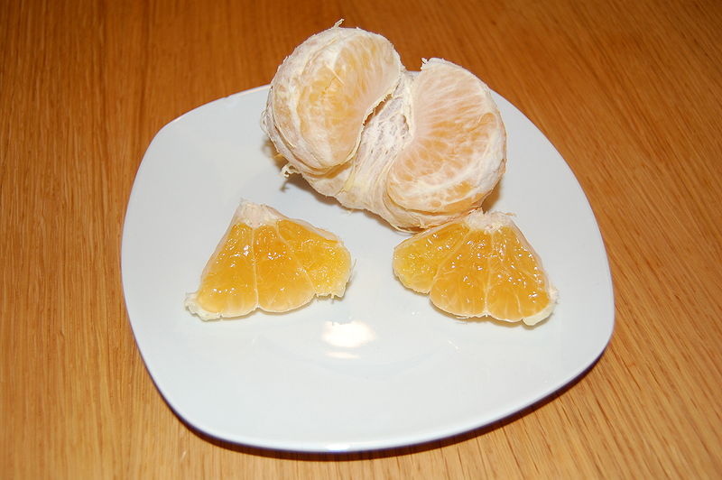 Ugli (Citrus x tangelo) Fruchtstücke auf Teller